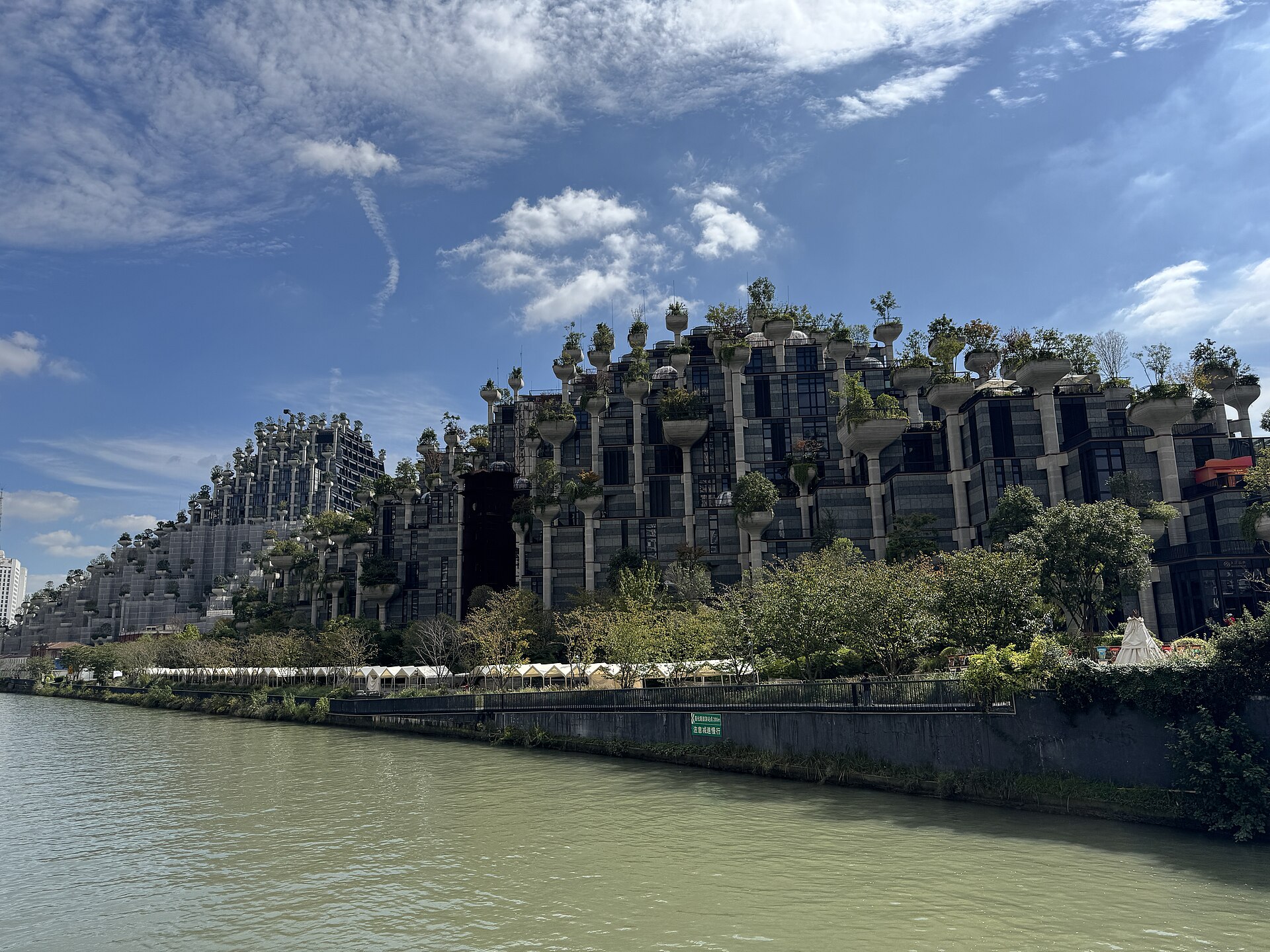 1000 Trees rising from the bank of Suzhou Creek in Putuo, its planted columns stacked like a green mountain