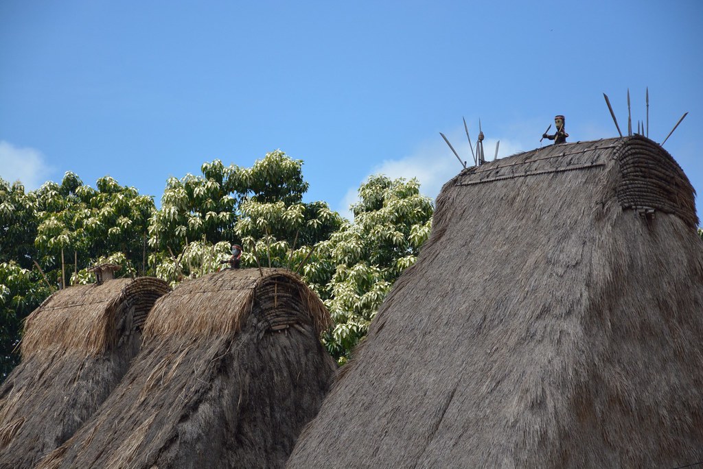 The towering thatched roofs of Tololela village rising against a blue sky