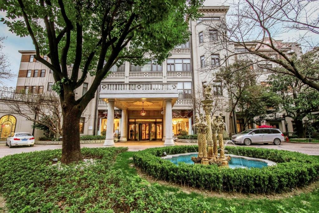 The columned mansion entrance of Shanghai Donghu Hotel, with a small fountain and manicured lawn in front